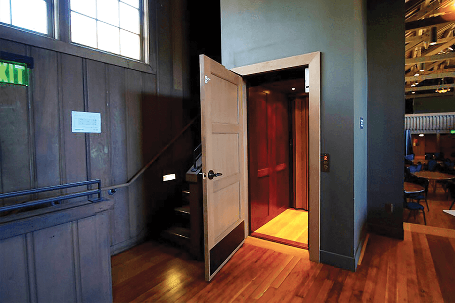 hybrid lift in building with wood panels showing door open