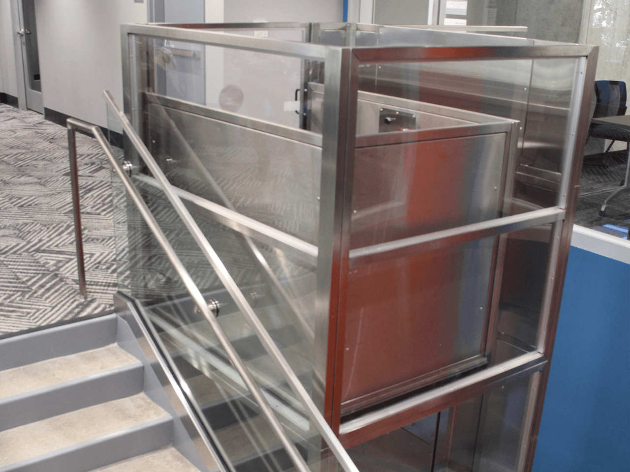 enclosed lift plexi in stainless steel and clear laminated safety glass shown from back