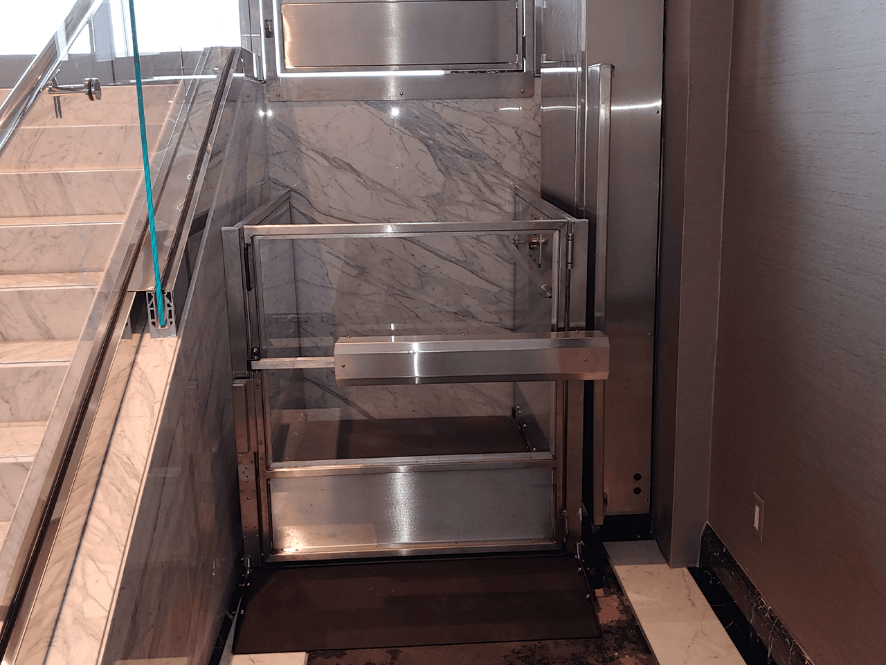unenclosed lift in brushed stainless steel with (custom) matching flip-up ramp cover