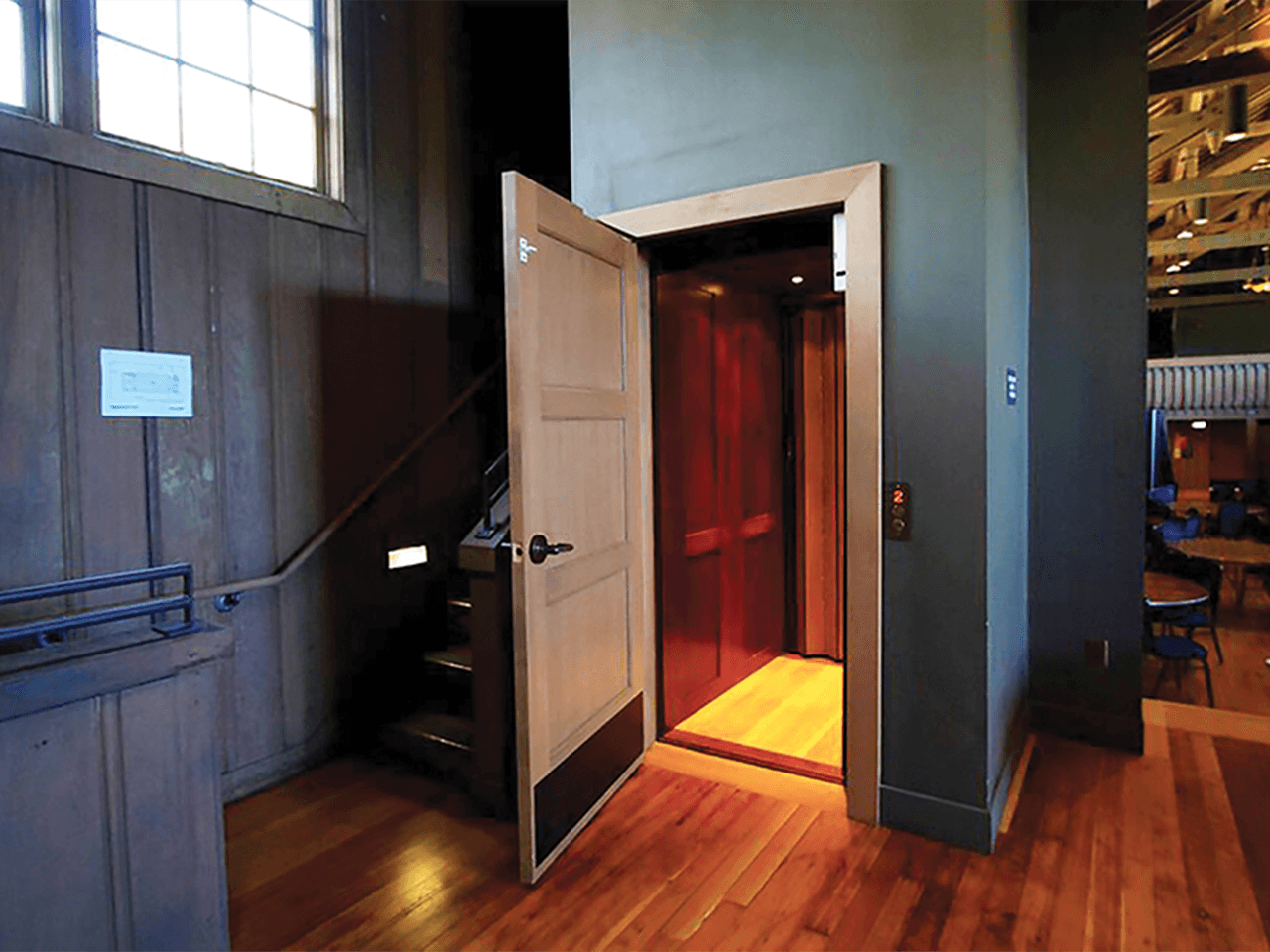 hybrid lift in building with wood panels showing door open