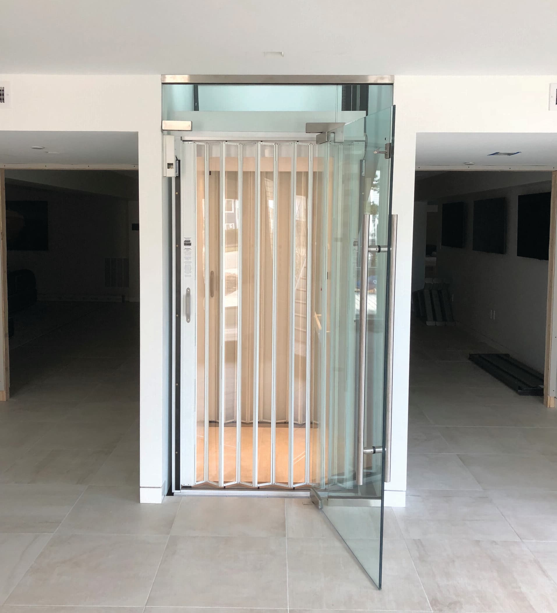symmetry resi elevator glass and white cab with clear accordion gate